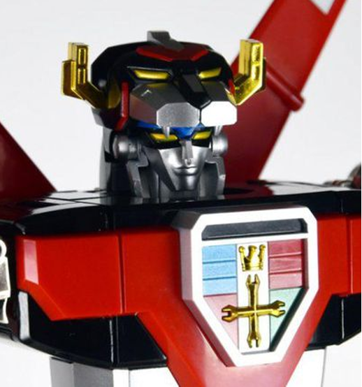 A closeup of a Voltron figurine, showing a blue and silver face nested within the mouth of a Black lion. 